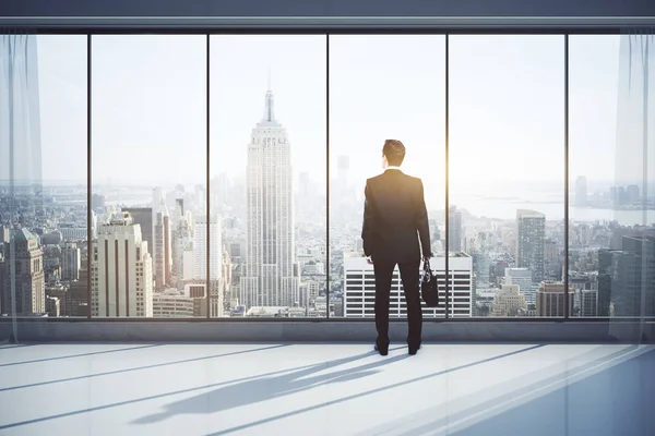 Vista trasera del hombre con maletín en el interior moderno con vista a la ciudad, mirando a la distancia. Concepto de investigación. Renderizado 3D —  Fotos de Stock