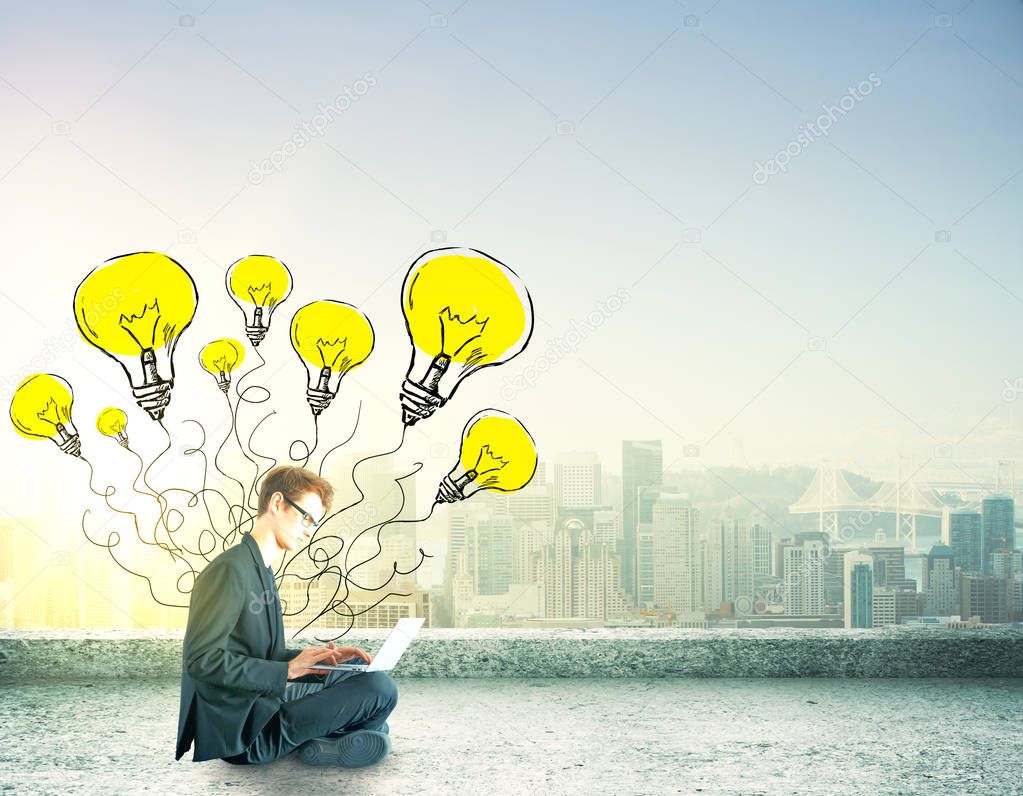 businessman sitting with laptop with lighbulb drawings. idea concept