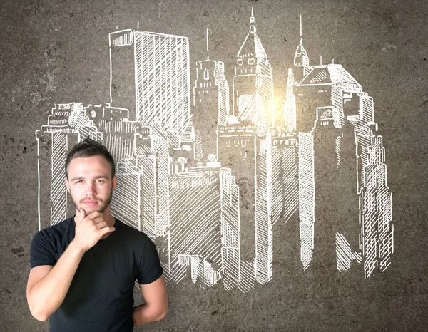 Бизнесмен думает и рисует панораму города на стене — стоковое фото