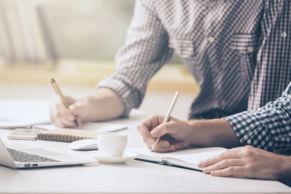 Dos tipos escribiendo en primer plano del bloc de notas —  Fotos de Stock