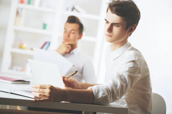 Koncepce týmové práce. Dva atraktivní mladý bělošský muži dělají papírování v moderní kanceláři — Stock fotografie