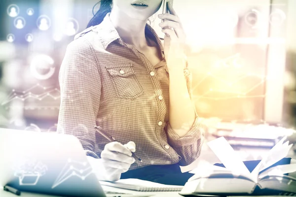 Attractive caucasian woman at workpace with abstract business charts talking on the phone and working on project. Accounting concept. Toned image — Stock Photo, Image