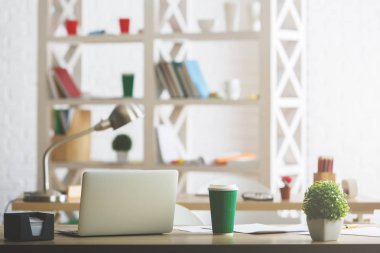 Dizüstü bilgisayar, lamba, kahve fincanı, bitki ve diğer öğeleri ile yaratıcı tasarımcı masa üstü. Modern ofis kavramı
