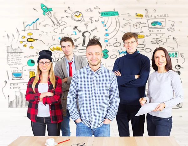 Equipe jovem de homens e mulheres europeus atraentes que estão no local de trabalho com esboço de negócios criativo. Conceito de trabalho em equipa — Fotografia de Stock