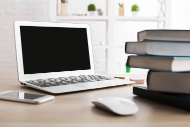 Yan görünümü hafif ahşap masa boş dizüstü bilgisayar, smartphone, kitap ve diğer öğeler. Yukarı alay