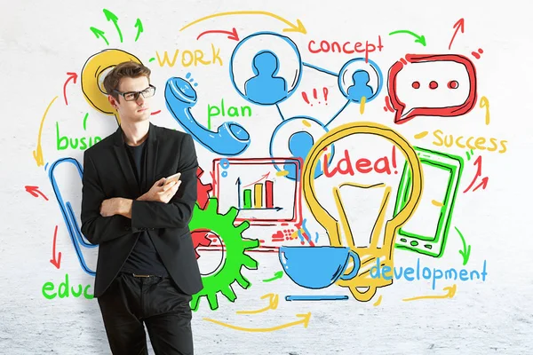 Doordachte jonge zakenman met smartphone op baksteen achtergrond met kleurrijke bedrijf schets. Communicatieconcept — Stockfoto