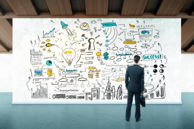 Arkadan görünüşü içinde modern iç duvar/billboard renkli iş kroki ile seyir düşünceli işadamı. Ekip çalışması kavramı. 3D render