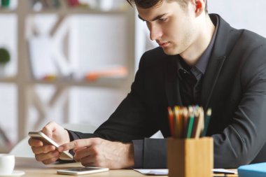 İşyerinde Smartphone kullanan adam