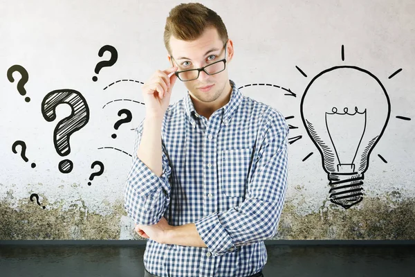 Thinking man with drawn question marks and lamp on concrete background. Idea concept — Stock Photo, Image