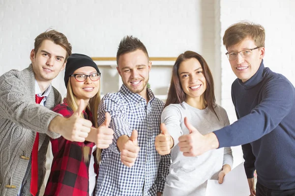 Young men and women showing thumbs up — Stock Photo, Image