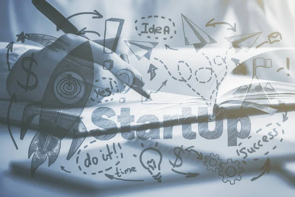 Side view and close up of female hand writing in notepad at workplace with creative rocket sketch. Entrepreneurship concept. Black and white image — Stock Photo, Image