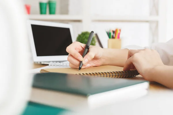 Feminino com laptop escrita no bloco de notas — Fotografia de Stock