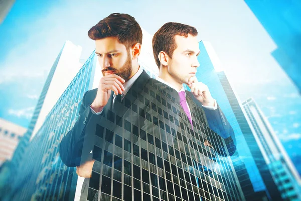 Two handsome thoughtful businessmen on blue city background. Teamwork concept. Double exposure — Stock Photo, Image