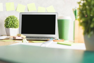 Bitkiler, not defterleri ve diğer malzemeleri ile dağınık ahşap masa üzerine yerleştirilen boş defter perde, yakın çekim. Sahte kadar reklam kavramı