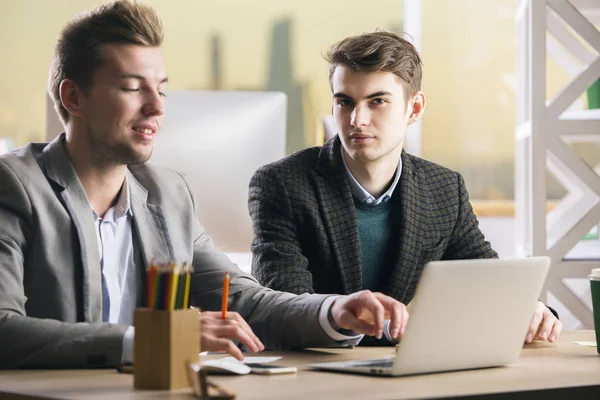 Machos usando computador e fazendo papelada — Fotografia de Stock