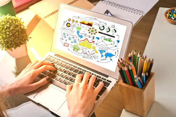 Mãos masculinas usando laptop com gráficos de negócios e diagramas, colocados em desktops de escritório de madeira com suprimentos, planta e luz solar. Conceito de trabalho — Fotografia de Stock