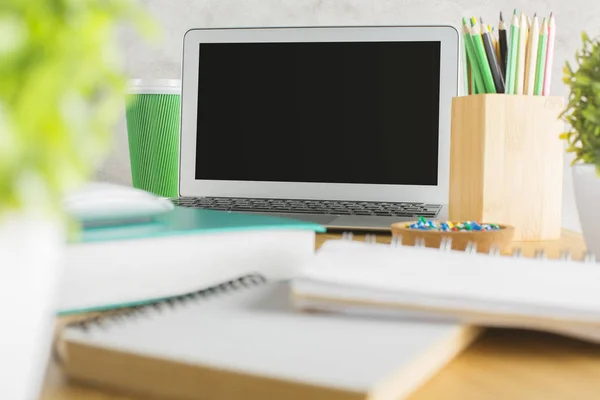Close-up de tela de laptop vazio colocado em mesa de madeira bagunçada com plantas, blocos de notas e outros suprimentos. Prepara-te, conceito de anúncio. — Fotografia de Stock