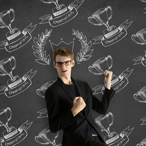 Cheerful european businessman with drawn crown and winner's cup on dark background. Winning concept — Stock Photo, Image