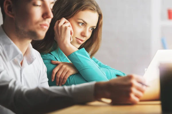 Retrato lateral de un atractivo joven y una mujer hablando por teléfono en el lugar de trabajo. Trabajo en equipo y concepto de comunicación — Foto de Stock