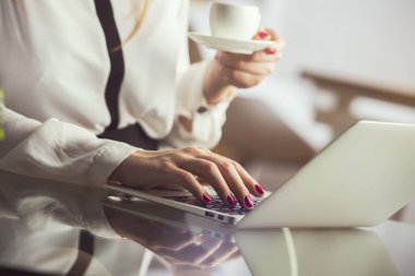 Kahve içme, dizüstü bilgisayar kullanarak bir kadın