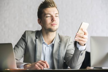 Dizüstü bilgisayar ve akıllı telefon olan adam