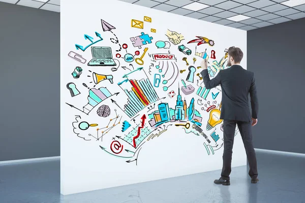 Zijaanzicht van de jonge zakenman in concrete interieur tekening business schets op whiteboard. — Stockfoto