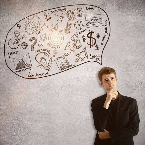 Handsome young businessman on concrete background thinking about business. — Stock Photo, Image