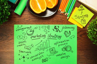 Ahşap masaüstü dekoratif bitkiler, turuncu yarısı ve iş kroki ile üstten görünüm yeşil kağıt sayfası.