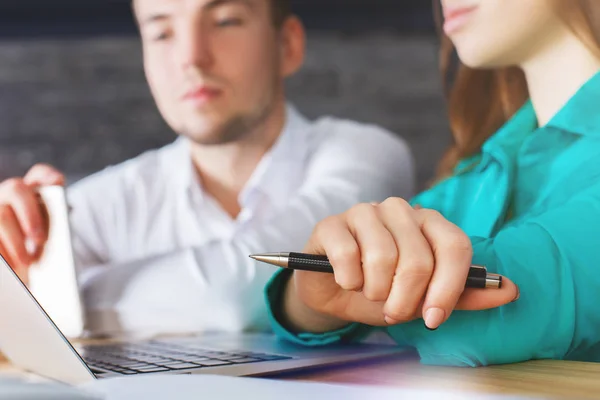 Close up portrait of young european male and female using laptop and smartphone at workplace. — Stock Photo, Image