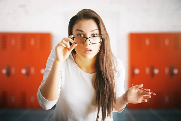 Verrast vrouw in interieur met kluisjes — Stockfoto