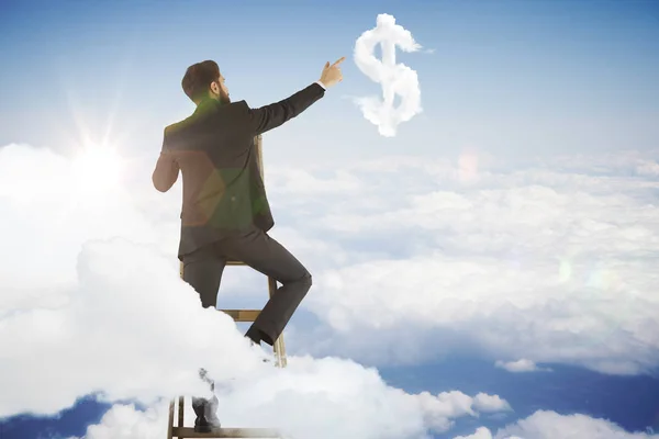 Visão traseira do homem de negócios no céu tentando alcançar a nuvem em forma de sinal de dólar. Conceito de riqueza — Fotografia de Stock