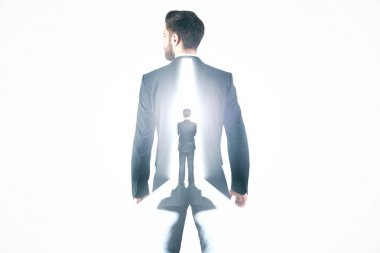 Arkadan Görünüm parlak ışık ile açık kapı önünde duran düşünceli iş adamı. Fırsat kavramı. Çift pozlama