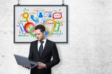 Yakışıklı genç iş adamı iş kroki çerçevesinde beton zemin üzerine dizüstü bilgisayar kullanarak. Atölye kavramı. 3D render