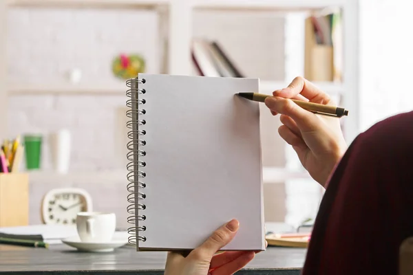 Female holding and writing in notepad — Stock Photo, Image