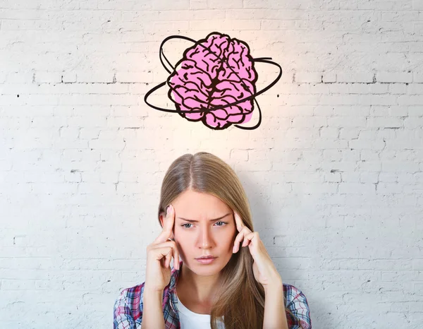 Nachdenkliche junge Frau mit Gehirnzeichnung auf Betongrund. Brainstorming-Konzept — Stockfoto