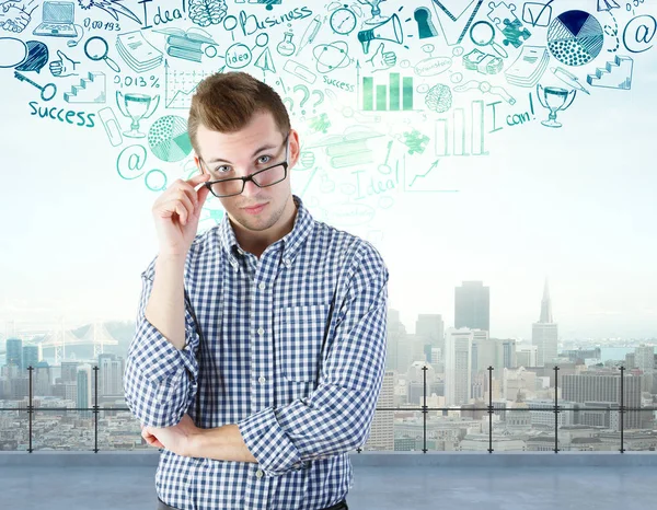 Portrait of thoughtful young man on rooftop with city view and business sketch. Research concept — Stock Photo, Image