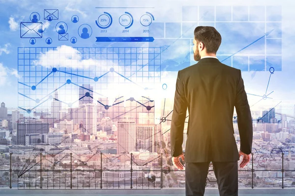 Baksidan på ung affärsman stående på taket med city view och abstrakta digitala affärsdiagram. Finance koncept — Stockfoto