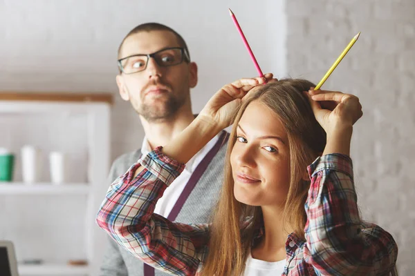 Atractivo hombre y mujer jugando con suministros — Foto de Stock