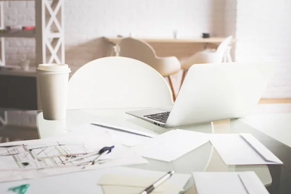 Nahaufnahme des Desktops des Ingenieurs mit Kaffeetasse, Blaupausen, Laptop und anderen Gegenständen — Stockfoto