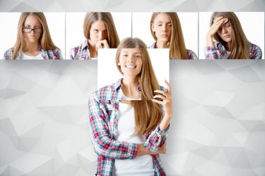 Genç Avrupa kadın kendini yüz gülümseyen poster arkasına saklanmış. Satır içinde belgili tanımlık geçmiş farklı ifadeler ile karşı karşıya. Duygu kavramı