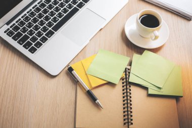 Ahşap ofis büro dizüstü bilgisayar, kahve fincanı, spiral not defteri ve renkli çıkartmalar, yakın çekim