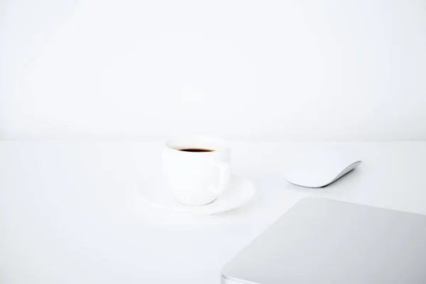 Coffee cup and closed laptop — Stock Photo, Image
