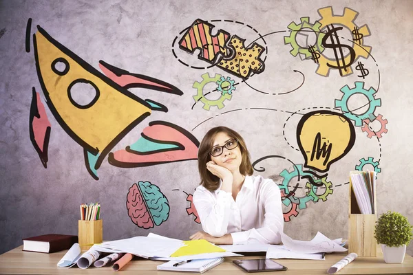 Pensativo joven mujer soñando despierto en el lugar de trabajo con cohete creativo boceto . — Foto de Stock