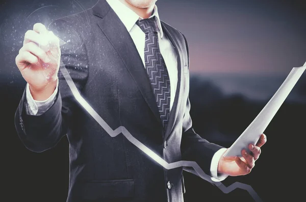 Young businessman with document in hand drawing digital chart arrow on dark background. Success concept — Stock Photo, Image