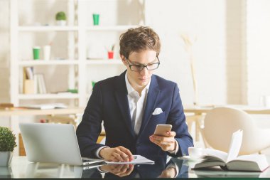 Laptop ve smartphone kullanarak çekici iş adamı