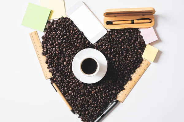 Widok z góry z filiżanki kawy, fasola, w kształcie serca, dostaw i puste białe smartphone. Koncepcja rano — Zdjęcie stockowe