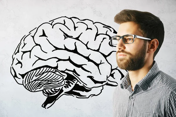 Бічний портрет красивого молодого бізнесмена на бетонному тлі з ескізом мозку. концепція мозкового штурму — стокове фото