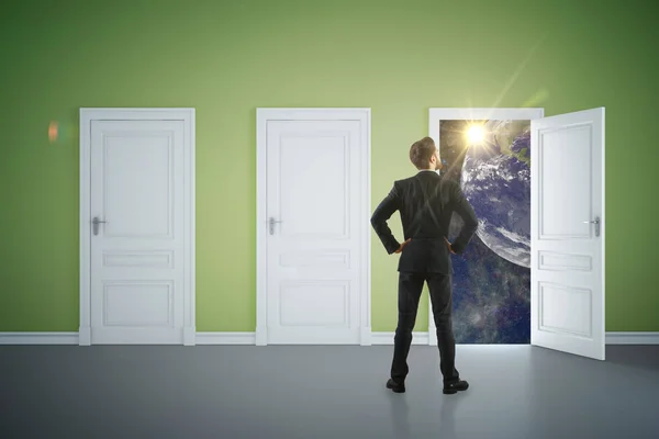 Back view of young businessman in green interior looking out of open door with space view. Success concept. 3D Rendering — Stock Photo, Image