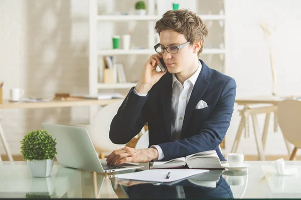 Uomo d'affari al telefono utilizzando il computer portatile — Foto Stock