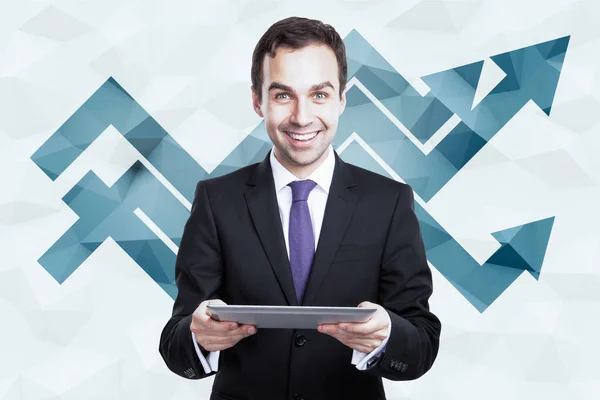 Fröhlicher Geschäftsmann mit Tablet auf polygonalem Hintergrund mit nach oben gerichteten Diagrammpfeilen. Erfolgskonzept — Stockfoto